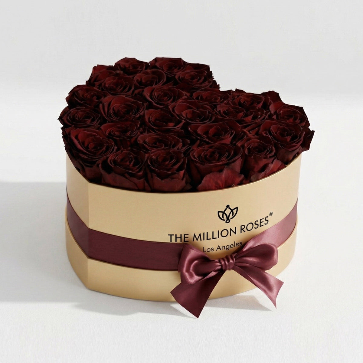 Gold gift box of burgundy roses with burgundy ribbon band and bow