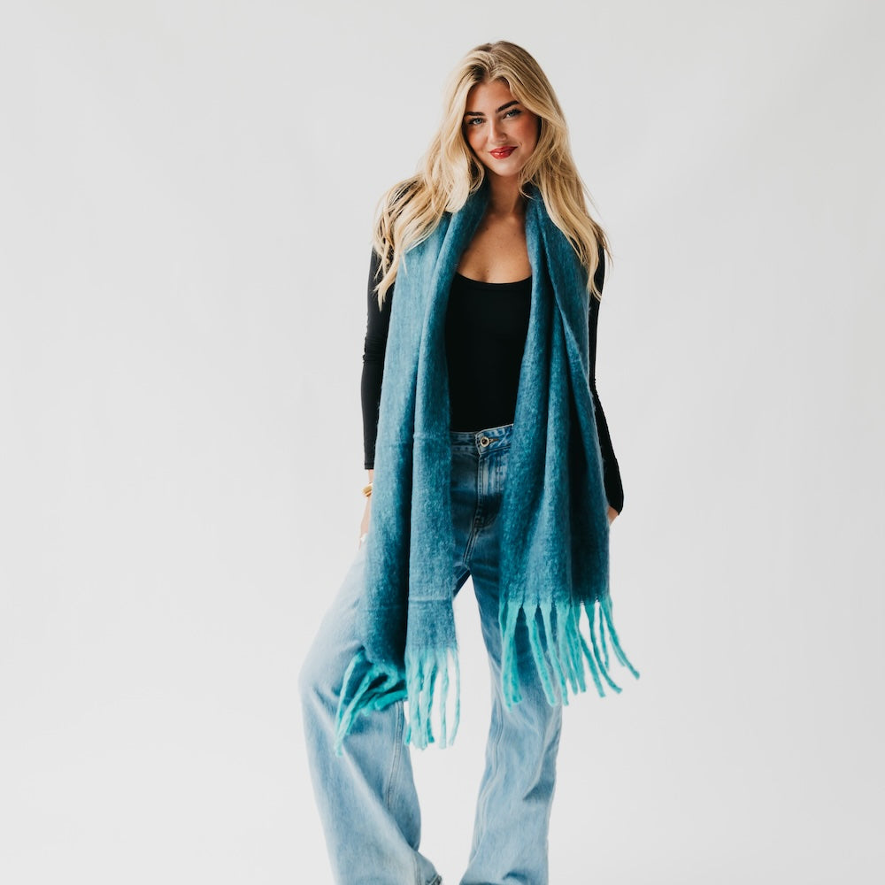Teal blanket scarf with fringed ends, worn as a long open layer