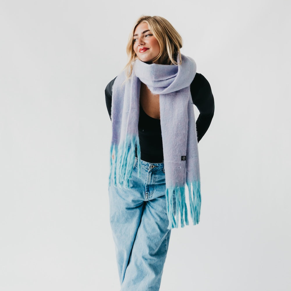 Lavender blanket scarf with fringed ends, styled open over a black top
