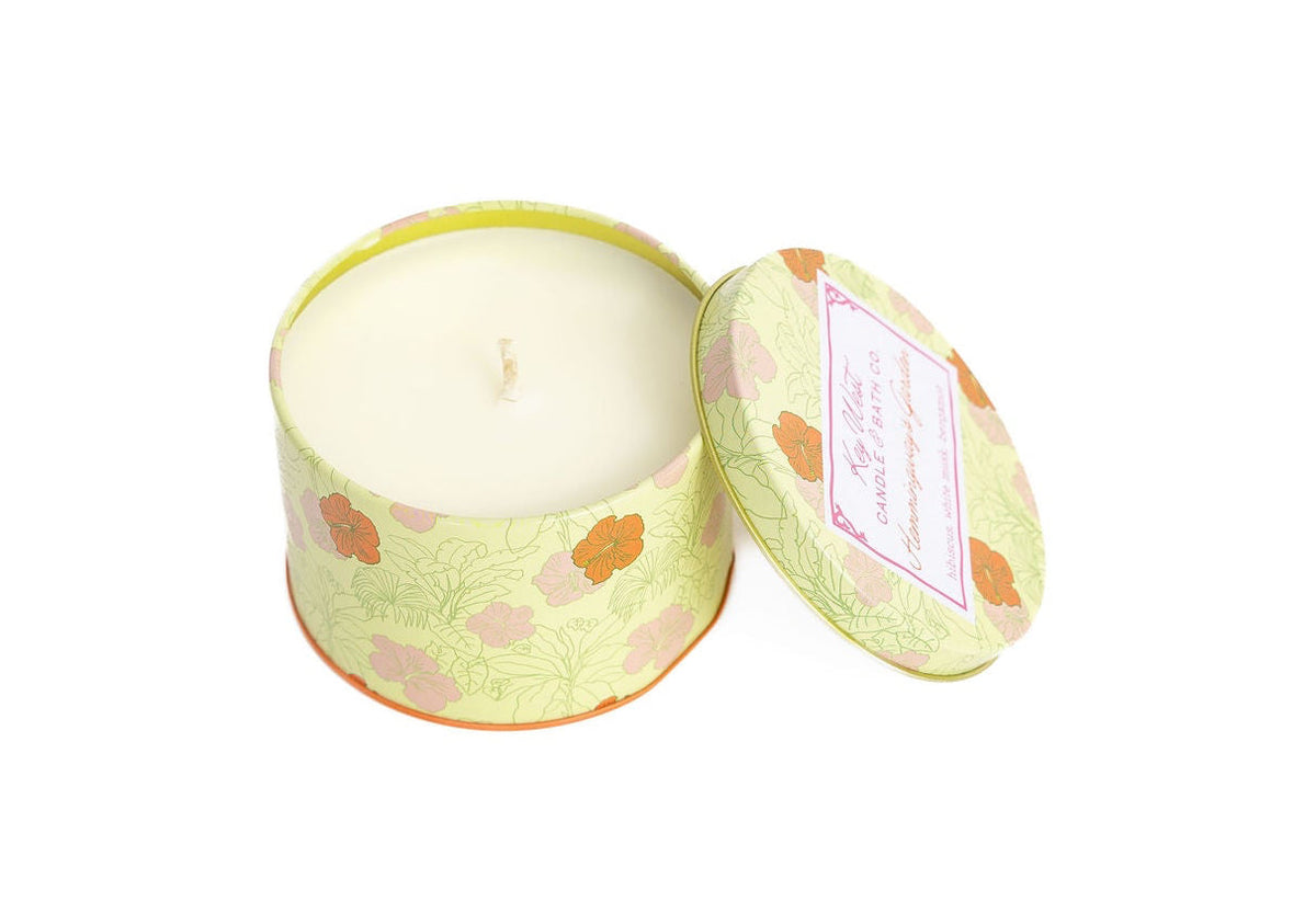 Round travel candle tin with open lid showing white candle inside floral print