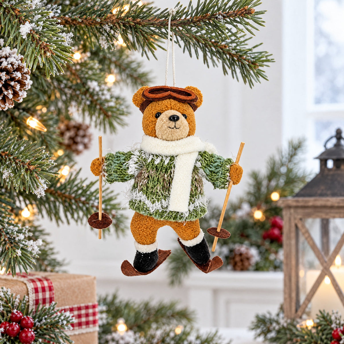 Skiing bear felt ornament hanging from string, wearing green sweater, white scarf, poles
