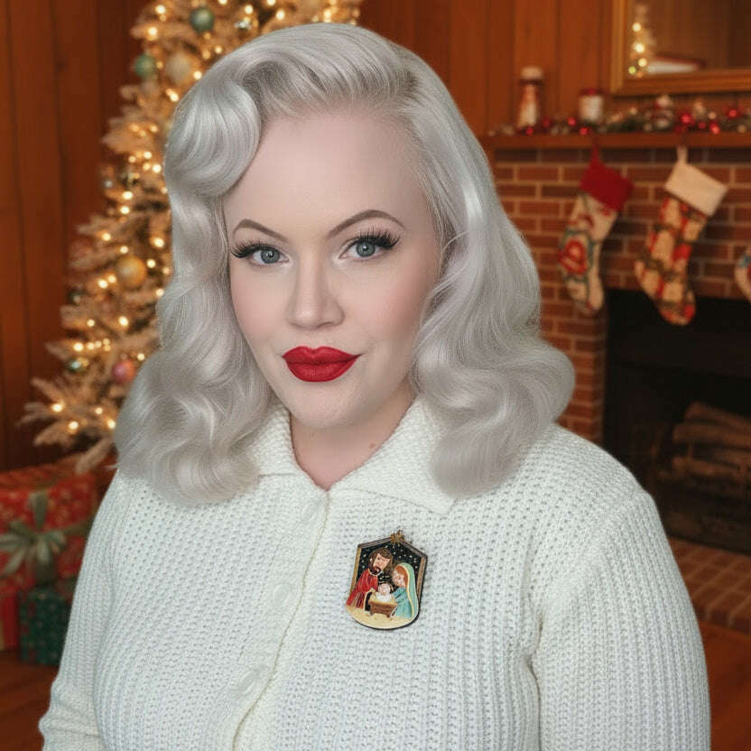 Enamel Nativity brooch featuring Holy Night figures on white knit sweater