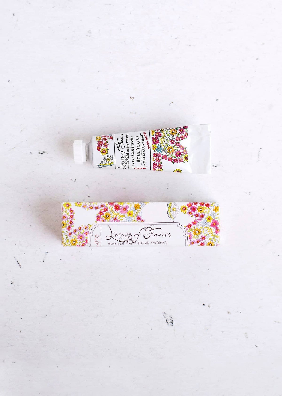 Small floral hand cream tube with matching floral sleeve label, white tube and colorful blossoms