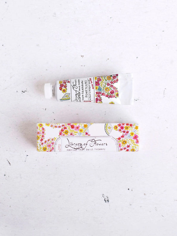 Floral hand cream tube and matching decorative label sleeve, white with colorful flowers