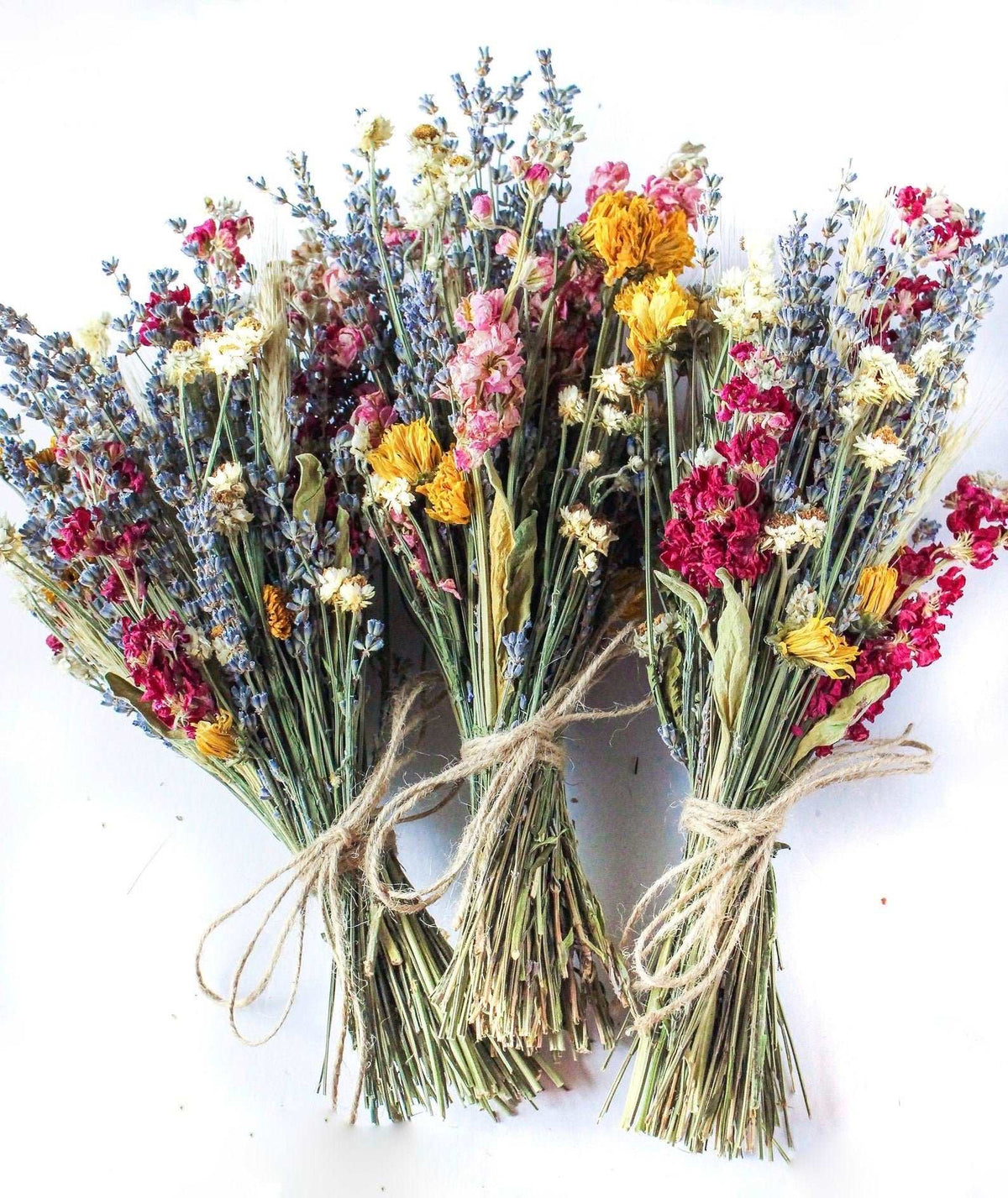 Dried wildflower bouquet tied with twine, mixed pink, yellow, blue, and white blooms