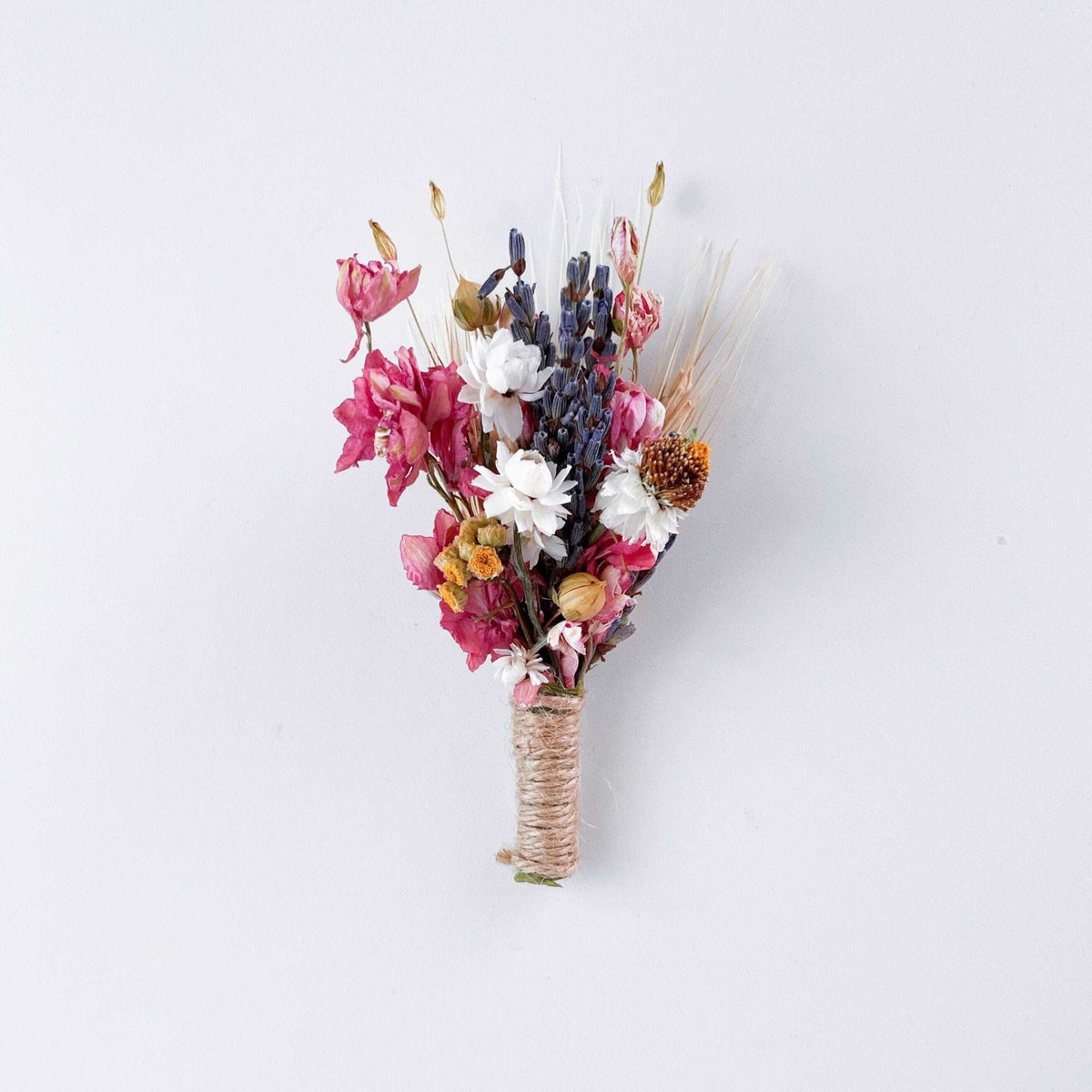 Small dried flower bouquet with pink and blue blooms, wrapped with twine at stems