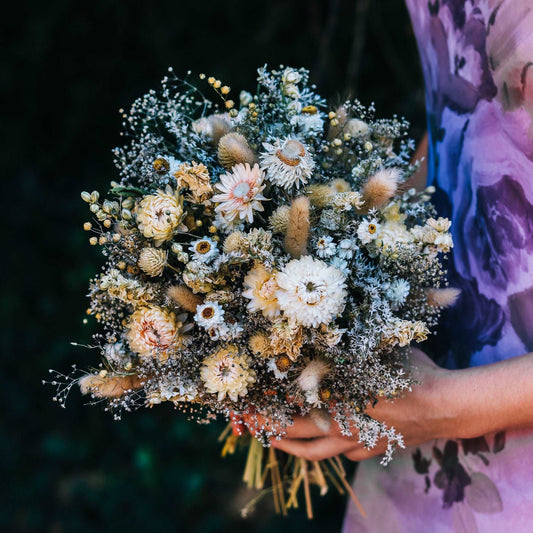 Dried flower bouquet in blush, cream, and dark tones with strawflowers and fine airy sprigs