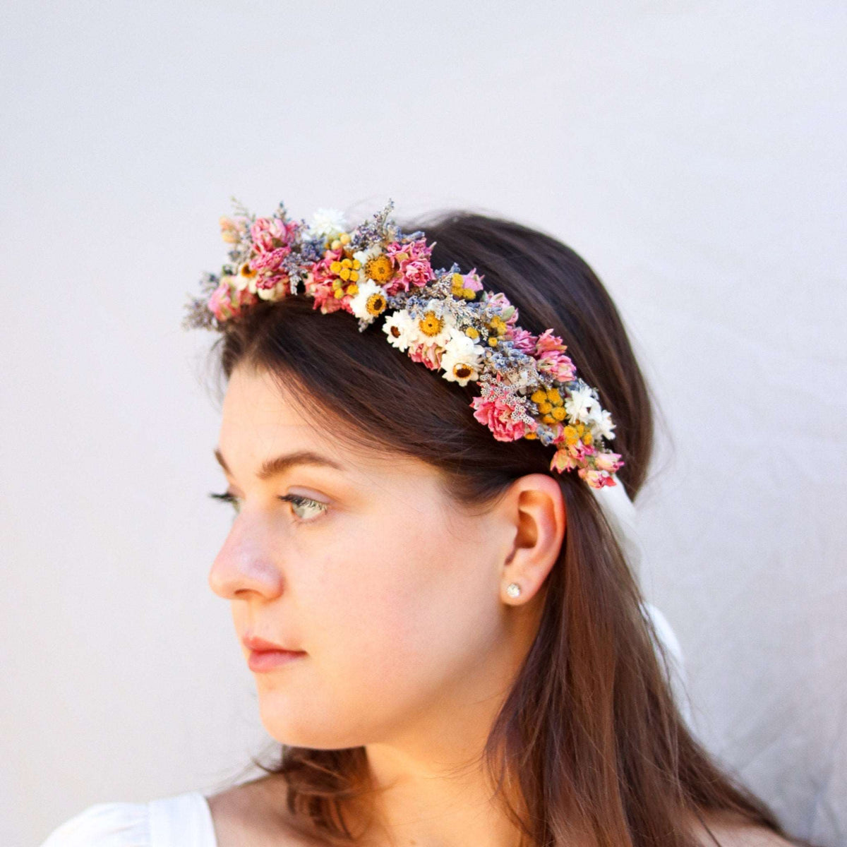 Dried flower crown with mixed pink, yellow, and white blossoms along a headband