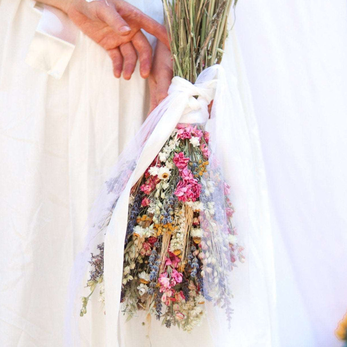 Dried flower bouquet with pink larkspur, lavender, and wheat on ribbon tied handle