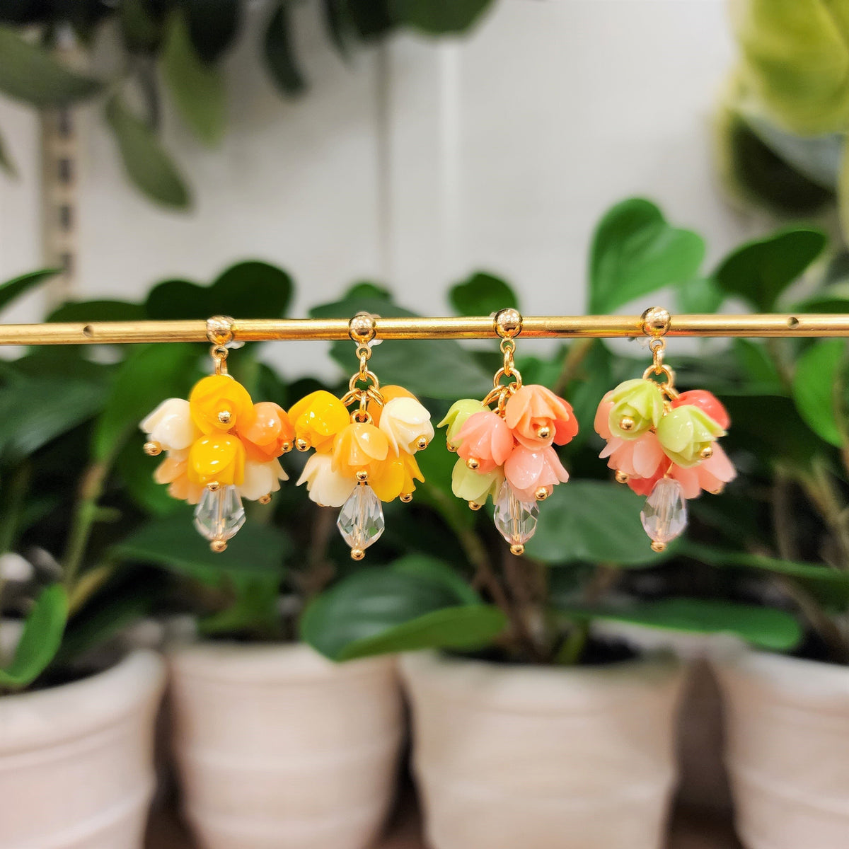 Gold-tone dangle tulip bouquet earrings with yellow, peach, pink, and green flower clusters