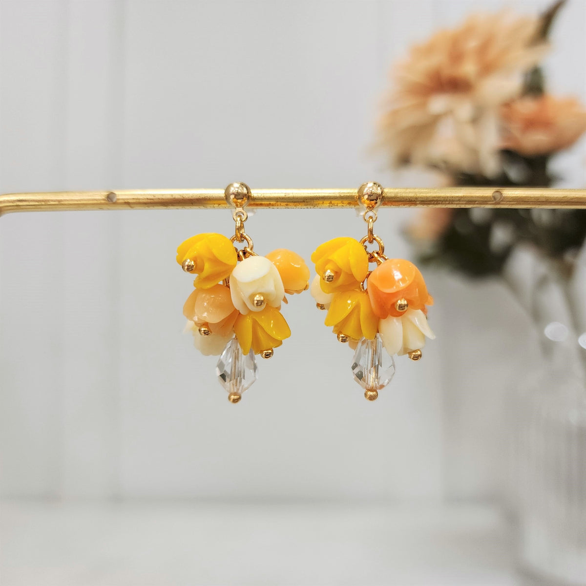 Gold-tone tulip bouquet dangle earrings featuring yellow and orange flower clusters