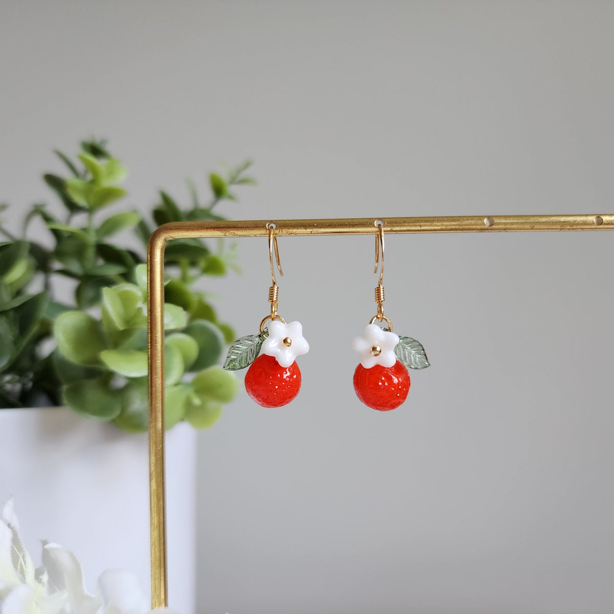 Orange fruit drop earrings with white flower center and green leaf, gold hooks