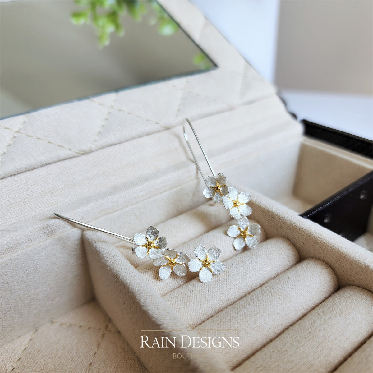 Silver forget-me-not style flower hook earrings on cream display box