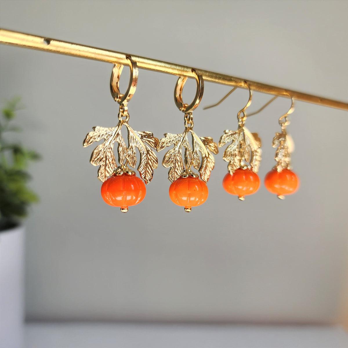 Set of gold-tone dangling pumpkin earrings with orange beads and leaf charms