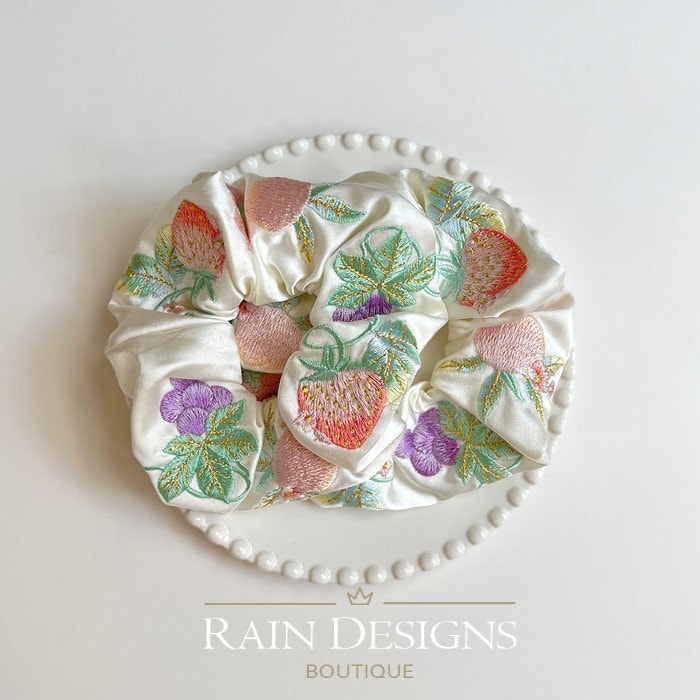 Ivory ruffled scrunchie covered in multicolor fruit and leaf embroidery.
