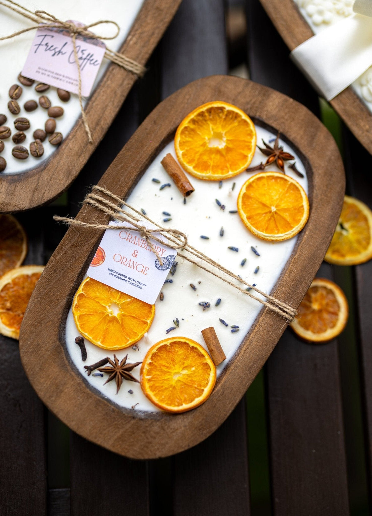 Soy candle in wooden dough bowl with orange slices and spice seeds; tied scent card