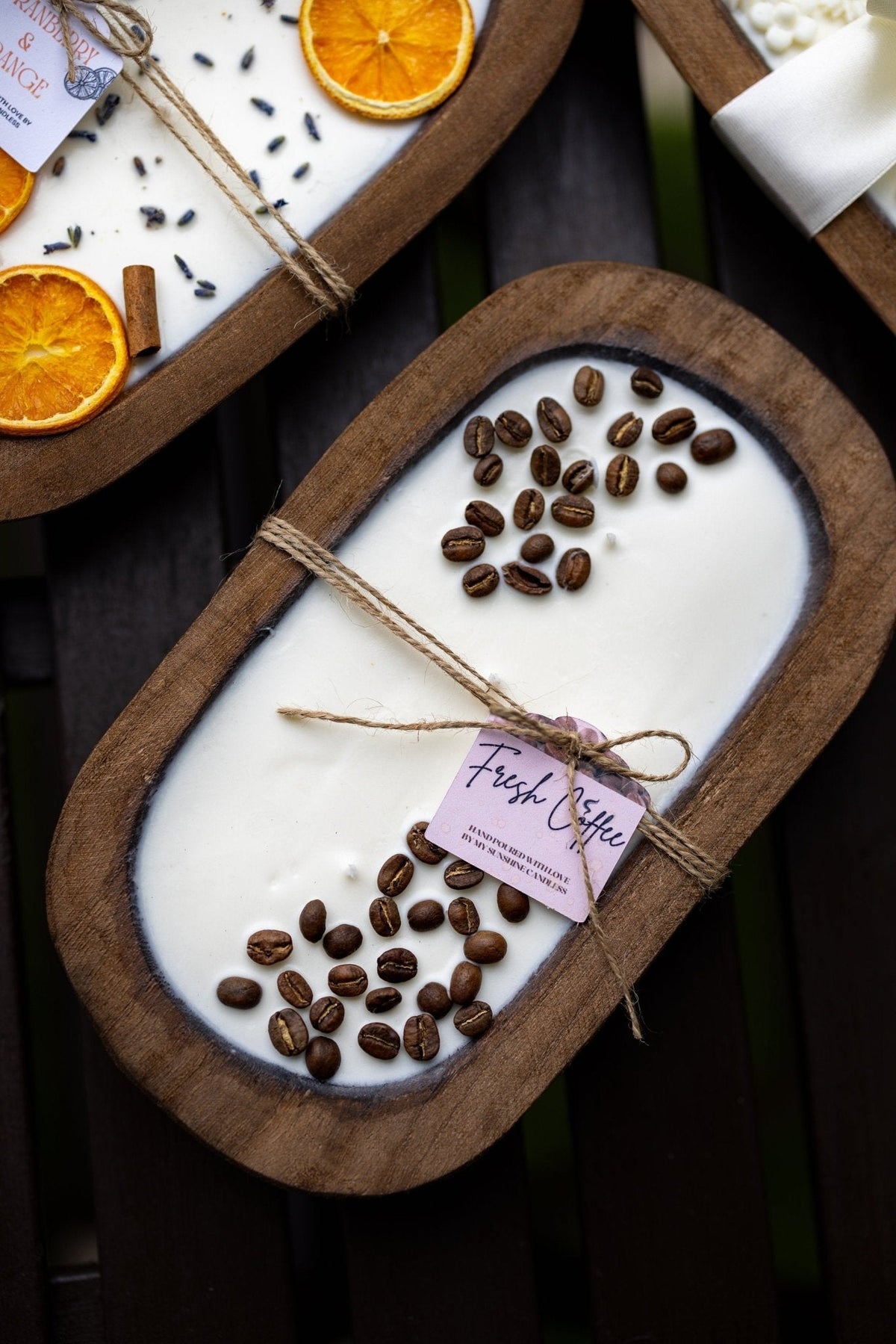 Coffee-scented candle in oval wooden bowl with coffee beans and twine-wrapped paper label