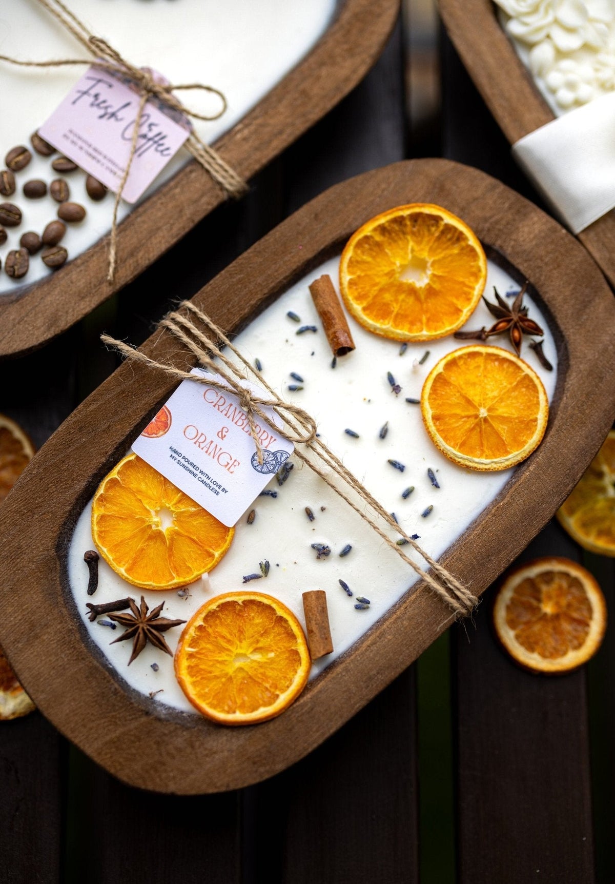 Soy candle in wooden orange dough bowl with orange slices, spice seeds, and cinnamon sticks