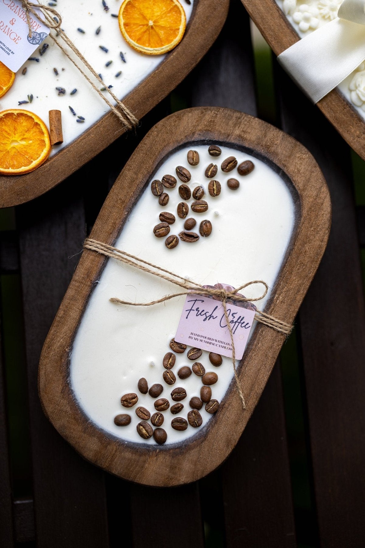 Coffee-scented candle in wooden bowl with coffee beans, twine tie, and label tag