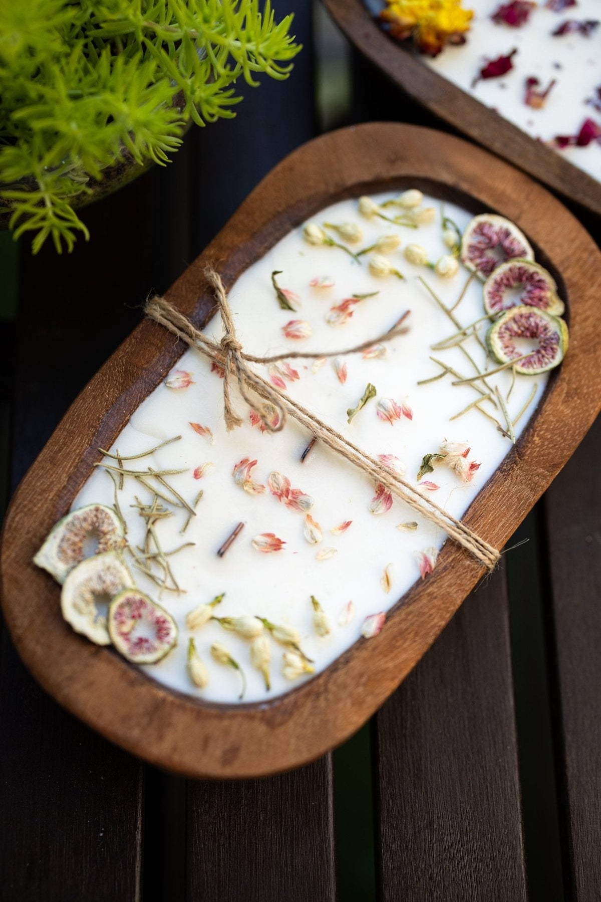 Wood dough bowl candle with white wax and fig-slice accents, twine wick across top