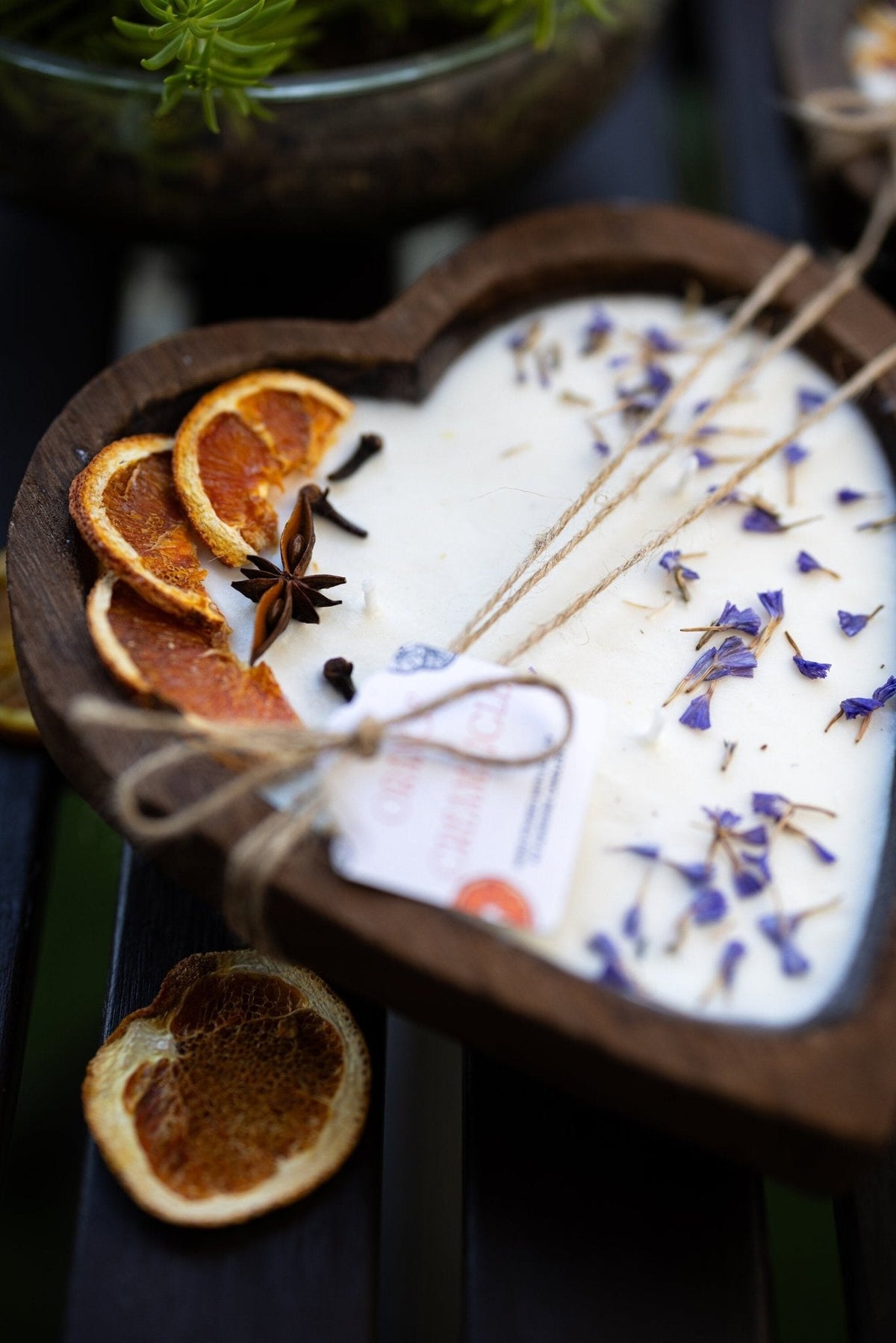 Heart-shaped white soy candle in wooden tray with orange slices and 3 cotton wicks