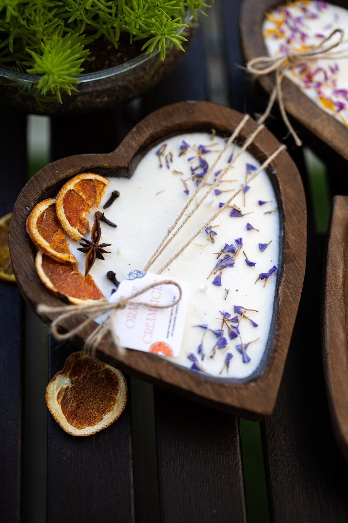 Heart-shaped white soy candle wax with orange slices, blue sprigs, and 3 cotton wicks