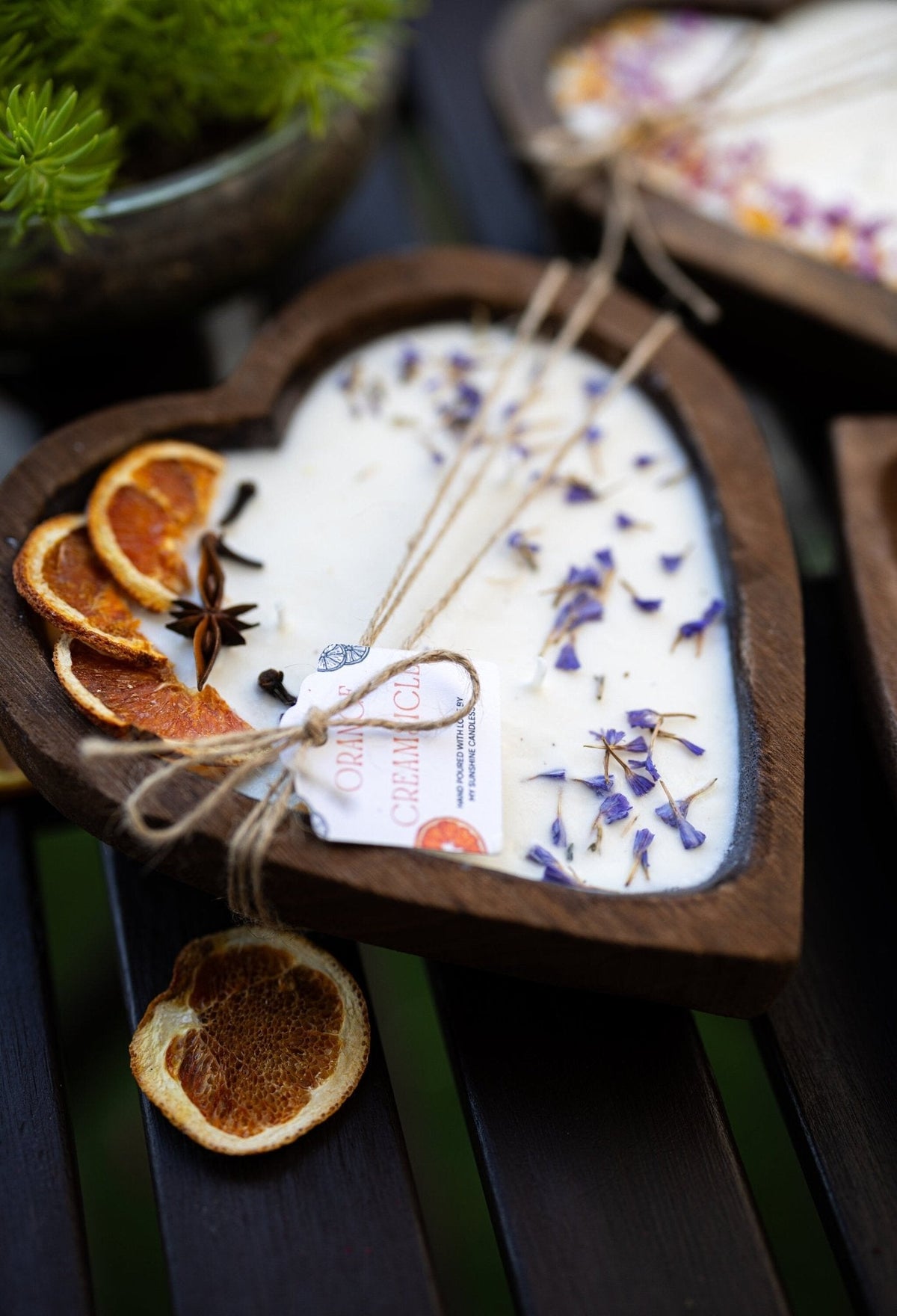 Heart-shaped white soy candle in wooden holder with orange slices and 3 cotton wicks