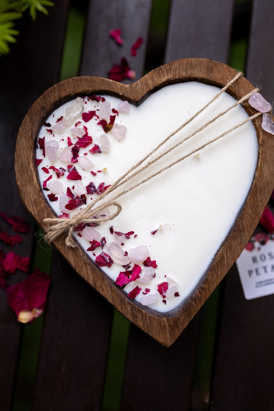 Heart-shaped wooden dough bowl candle, white wax with rose petals and three cotton wicks.