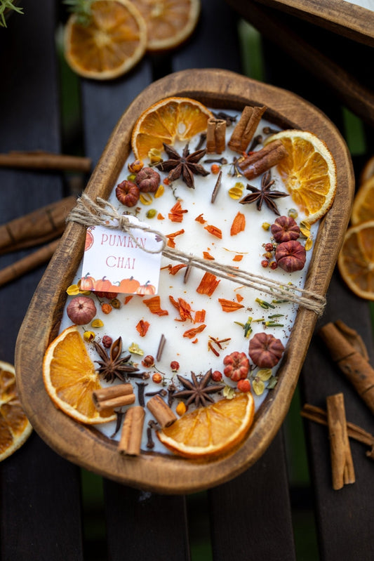 Wooden bowl candle with white wax topped with dried citrus slices and star anise