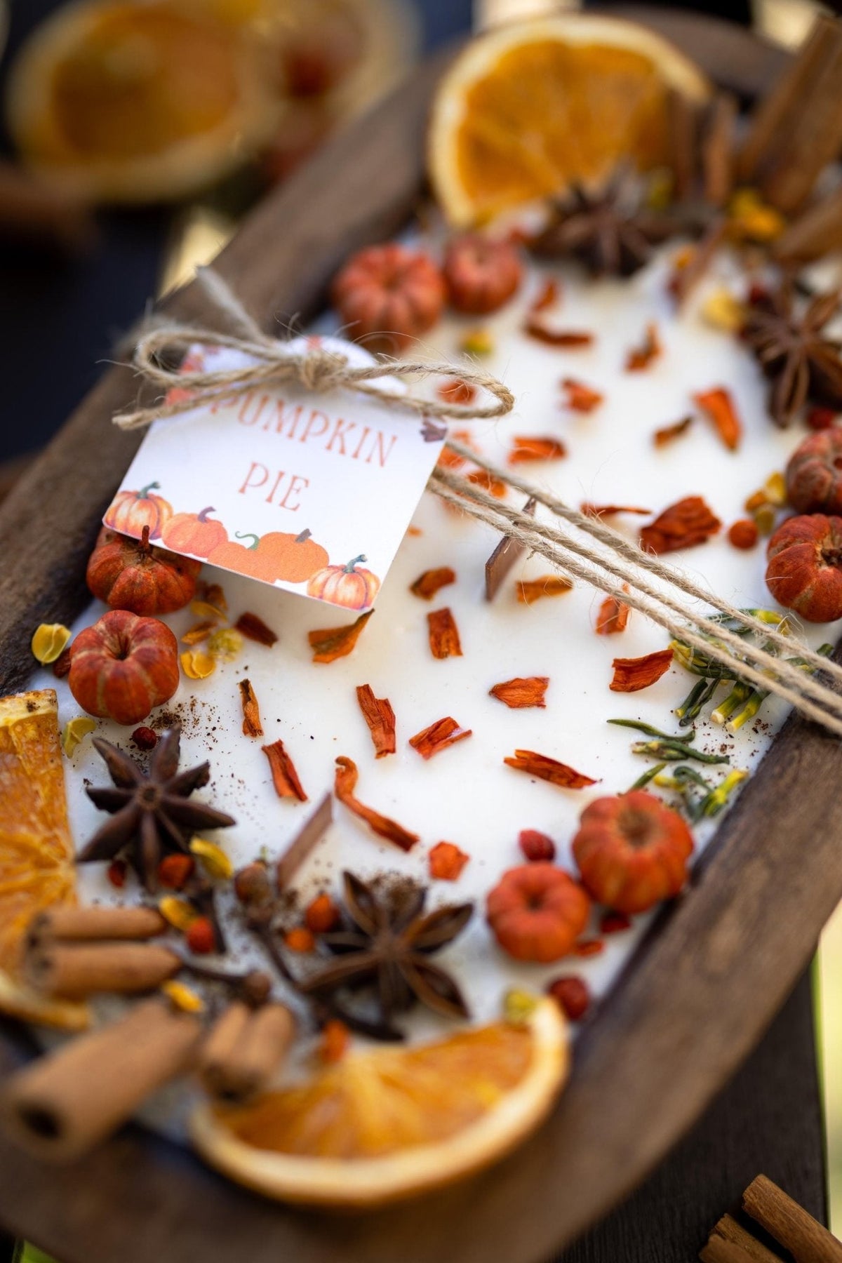 Large wooden candle bowl with pumpkin spice wax and spice mix, cinnamon sticks, orange slices