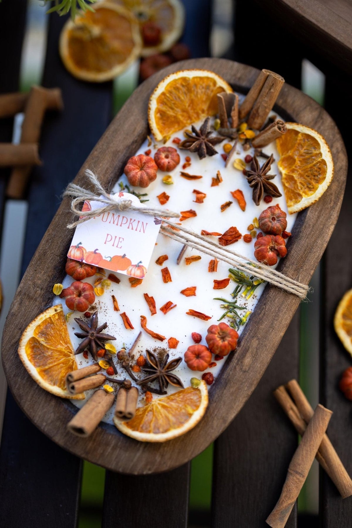 Large wooden candle bowl with pumpkin spice wax, dried orange slices and cinnamon sticks