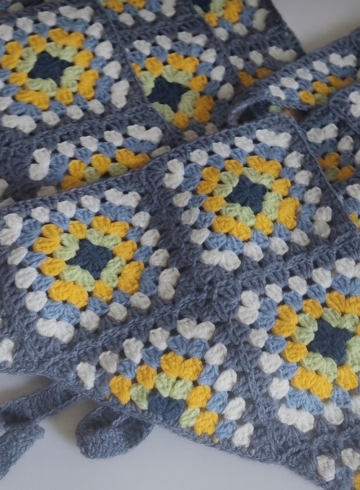 Blue crochet bandana with yellow and light blue granny square pattern and fringe