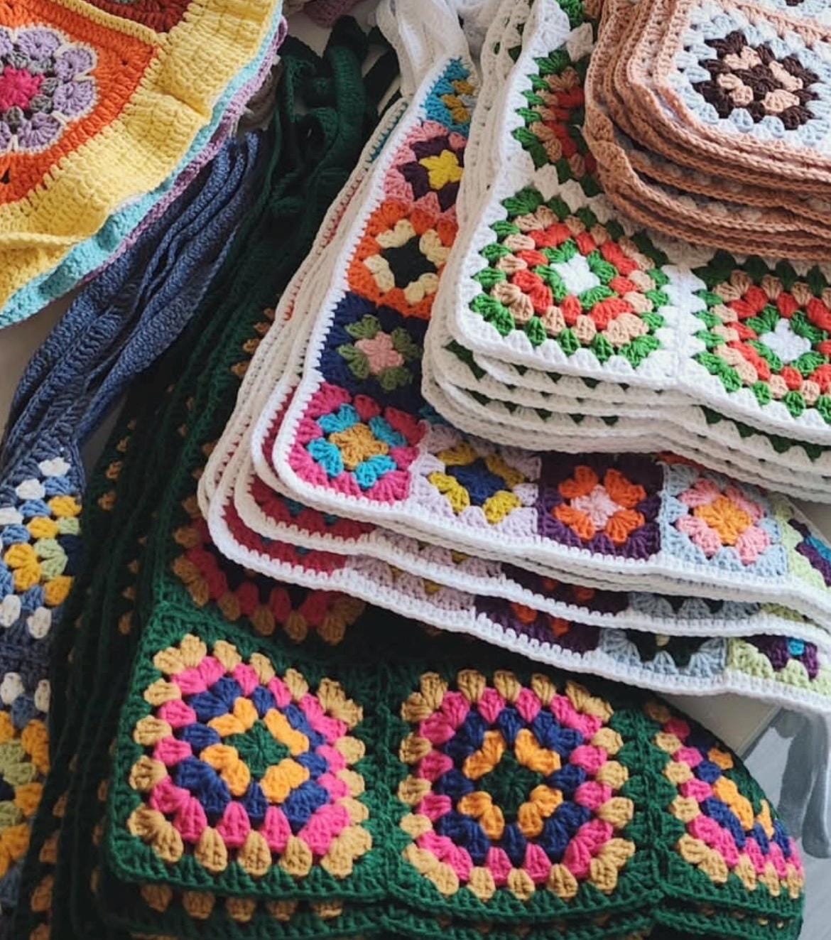 Stacked crochet bandanas with colorful granny squares on white edging and ties