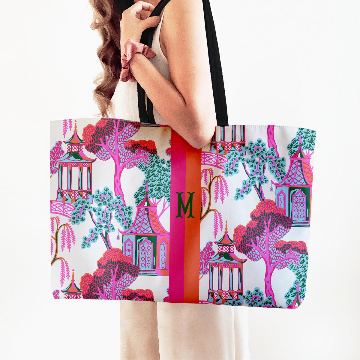 Pagoda-print tote bag with black webbed handles and central monogram