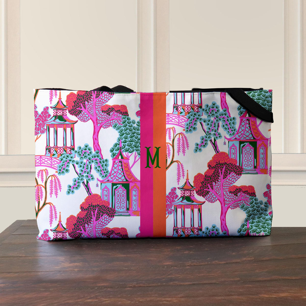 Pagoda-print tote bag with black webbed handles and a central monogram