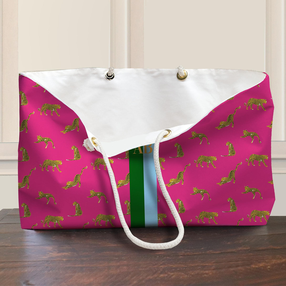 Pink leopard print tote opened to show white lining, rope handles, and grommets