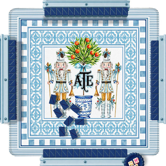 Square holiday mahjong mat with blue geometric borders, nutcrackers, a decorated tree and custom initials.