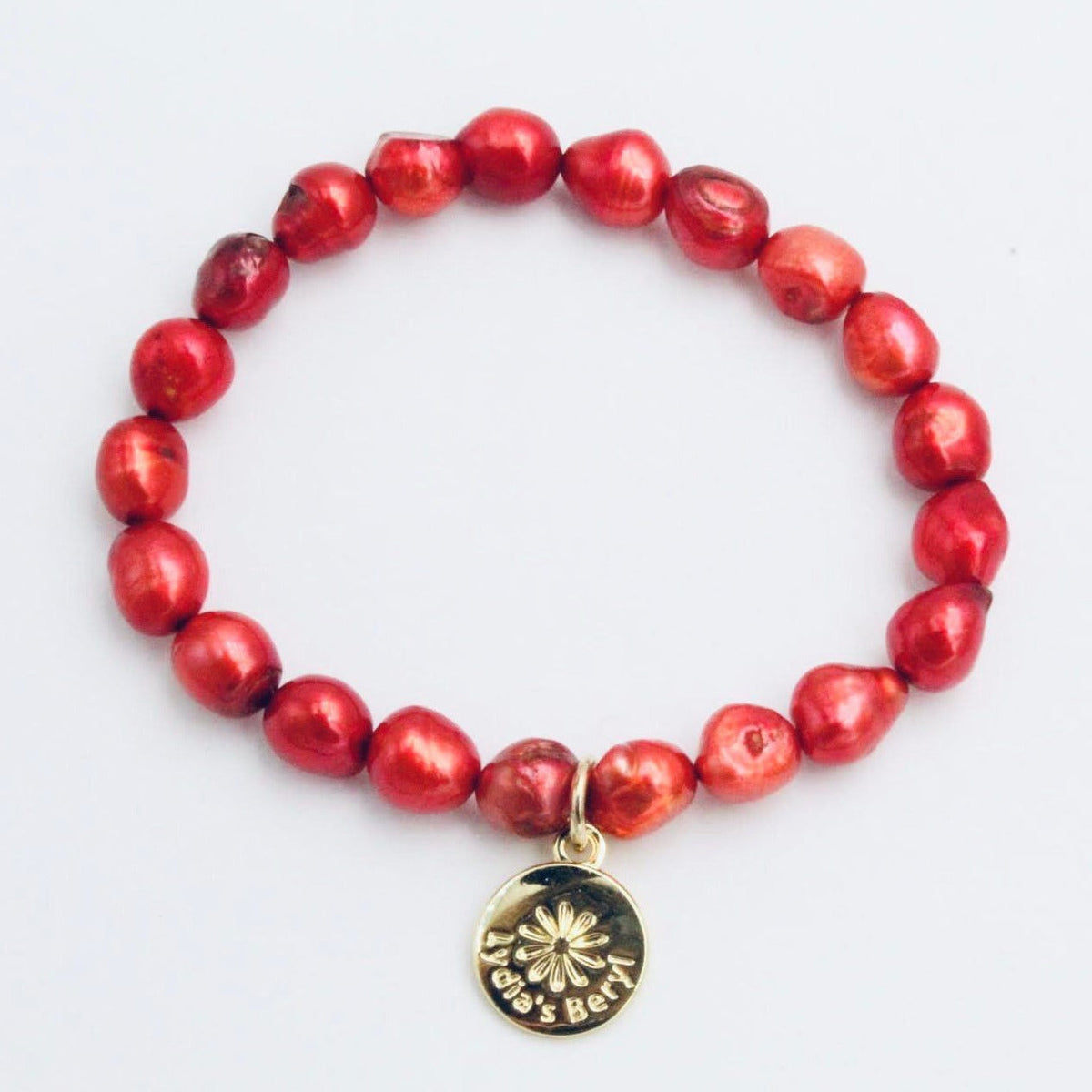 Red freshwater pearl bracelet with a gold-tone floral charm
