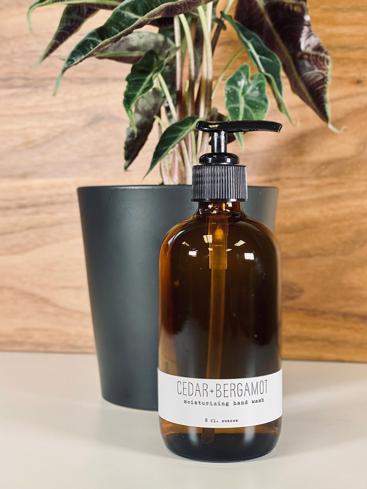 Amber hand wash bottle with black pump, cedar+bergamot label