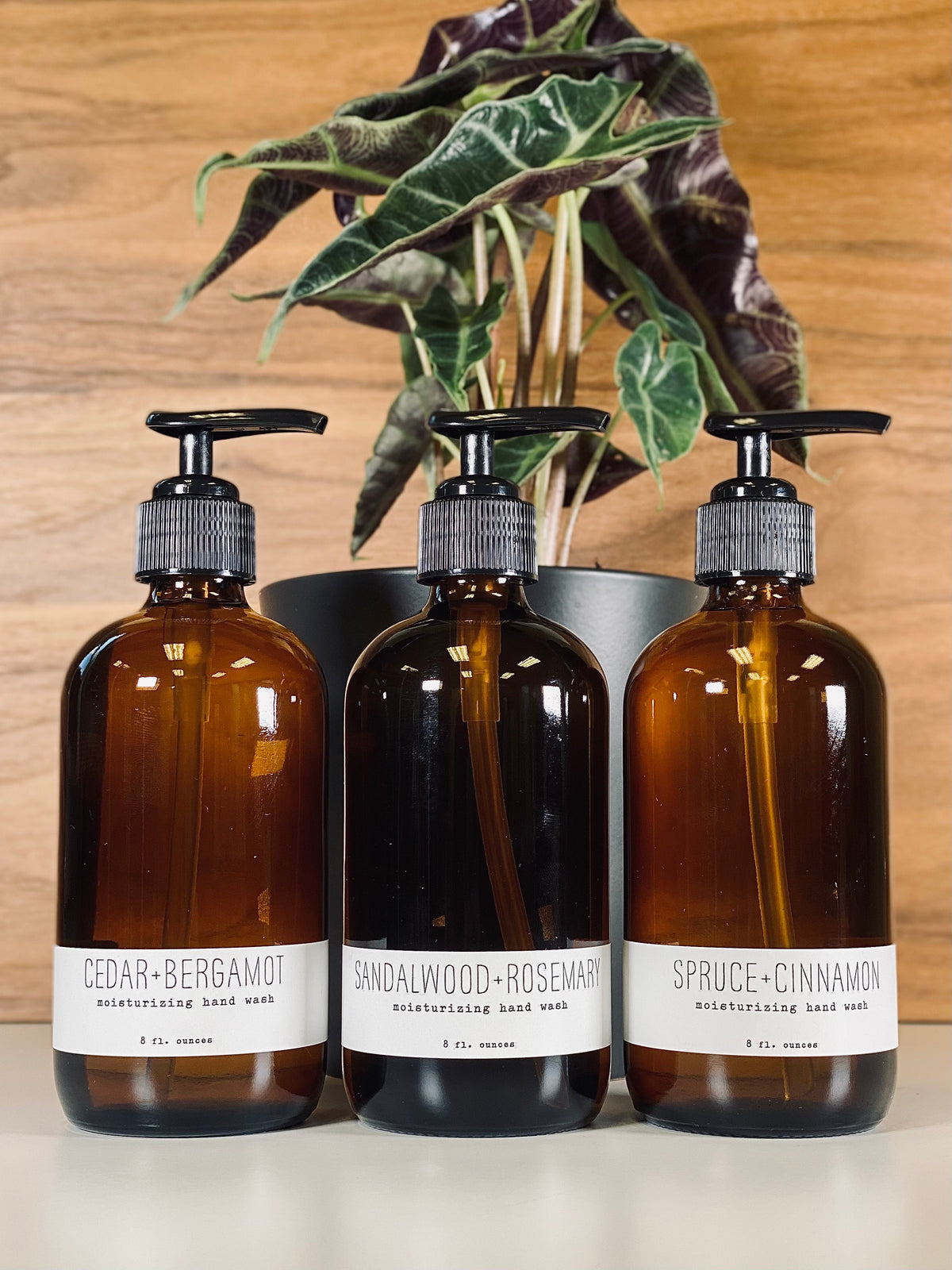 Amber hand wash bottles with black pump, cedar+bergamot label