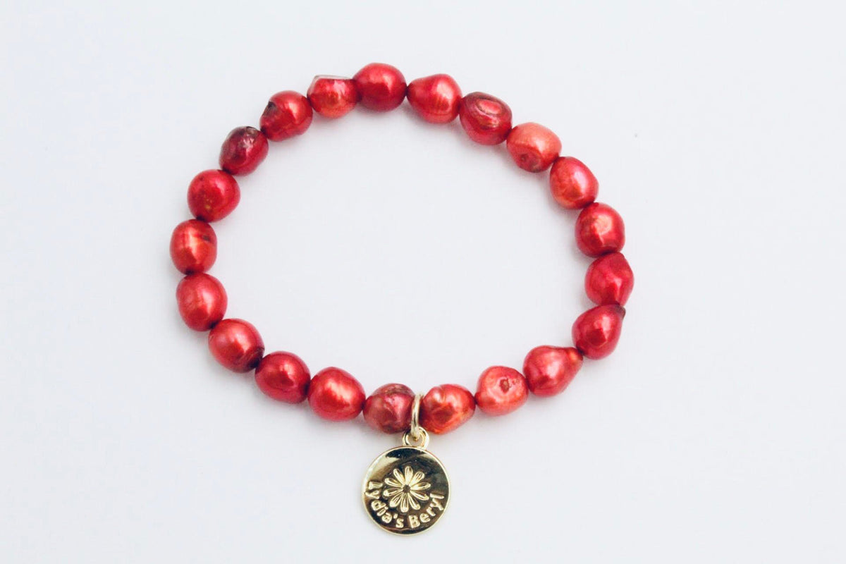 Red freshwater pearl bracelet with a gold-tone floral charm