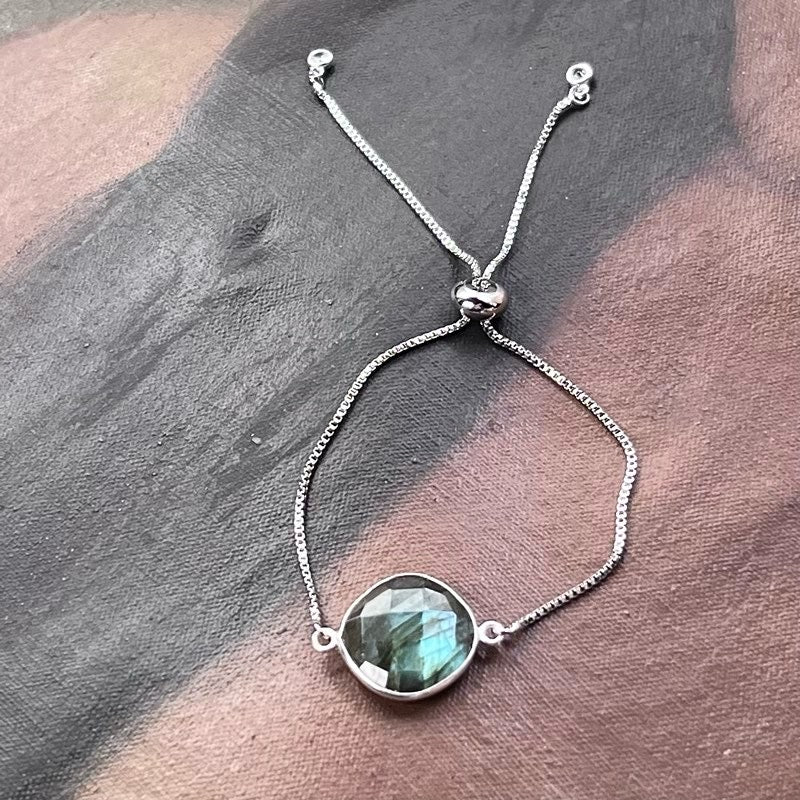 Adjustable silver bracelet with round labradorite gemstone centerpiece and chain links