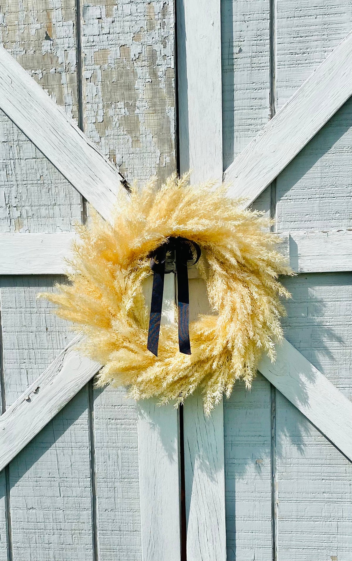Pampas wreath with navy bow ribbon and golden feathery ring
