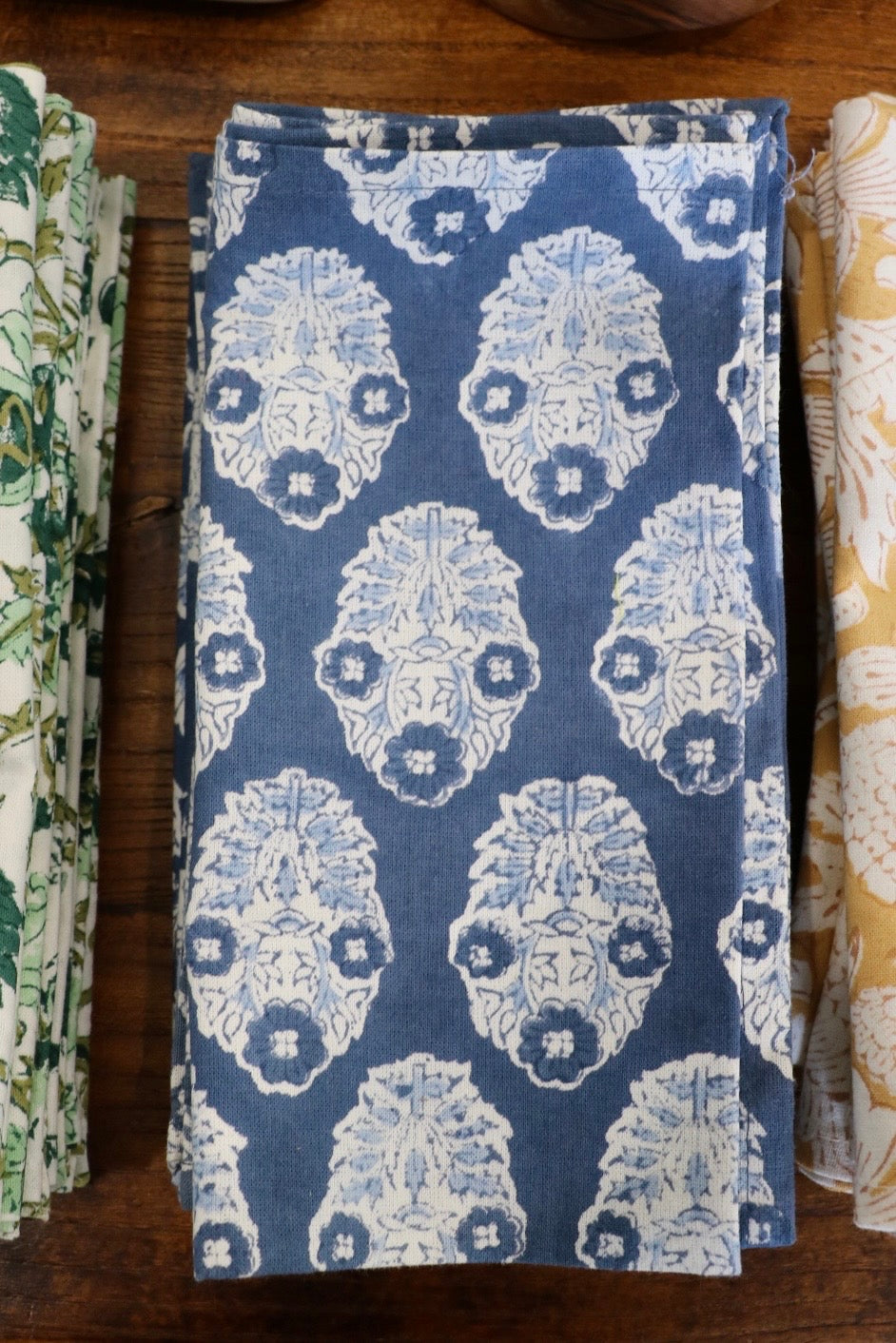 Botanical garden napkins in dark blue with white ornate floral medallion pattern, folded