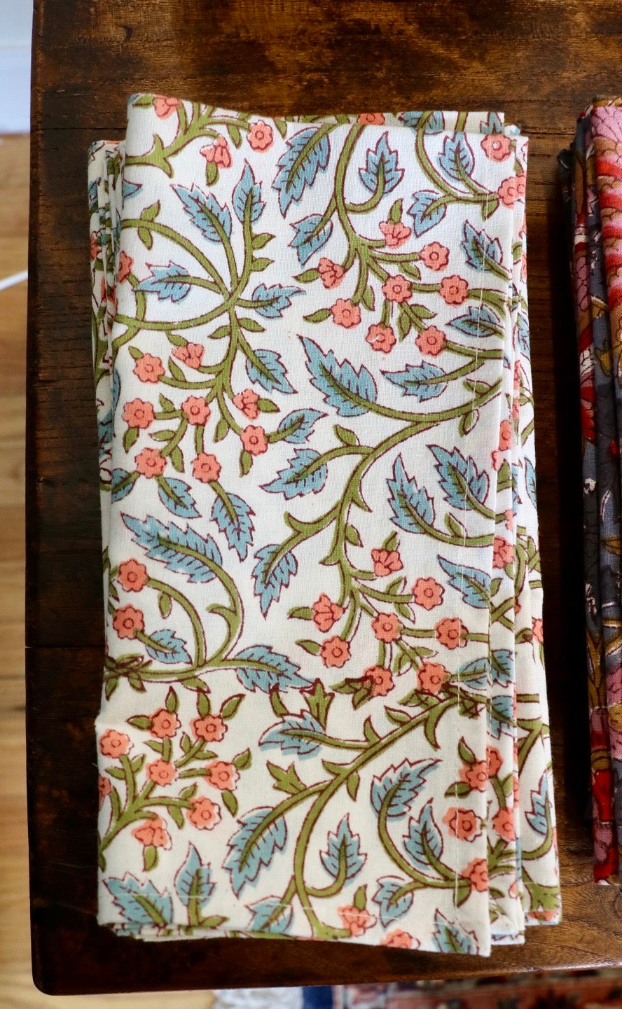 Botanical garden napkins in white with multicolor floral vine and leaf pattern, folded