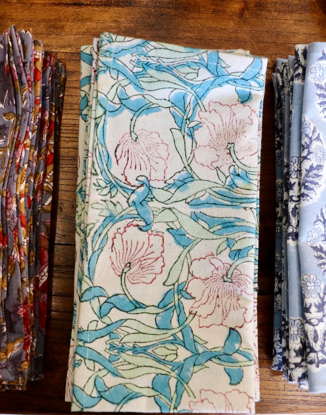 Botanical garden napkins in pale blue with pink floral vine and leaf pattern, folded