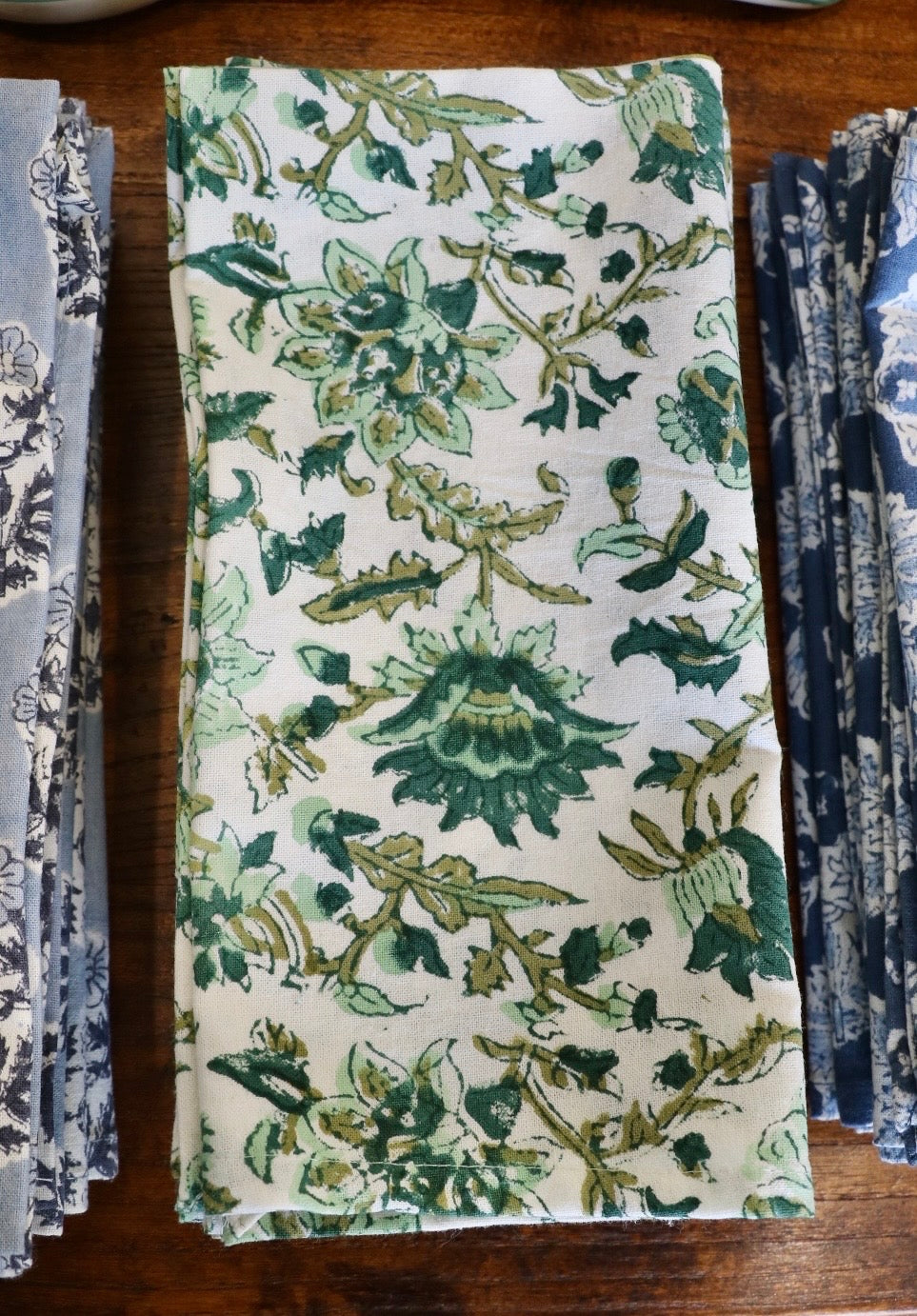 Botanical garden napkins in white with green leafy and branch pattern, folded rectangle