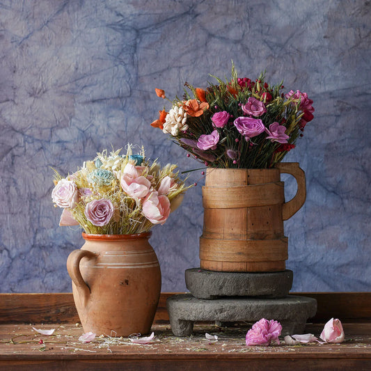 Dried floral and grass bouquets in two ceramic vases, pink and blue flowers with stems