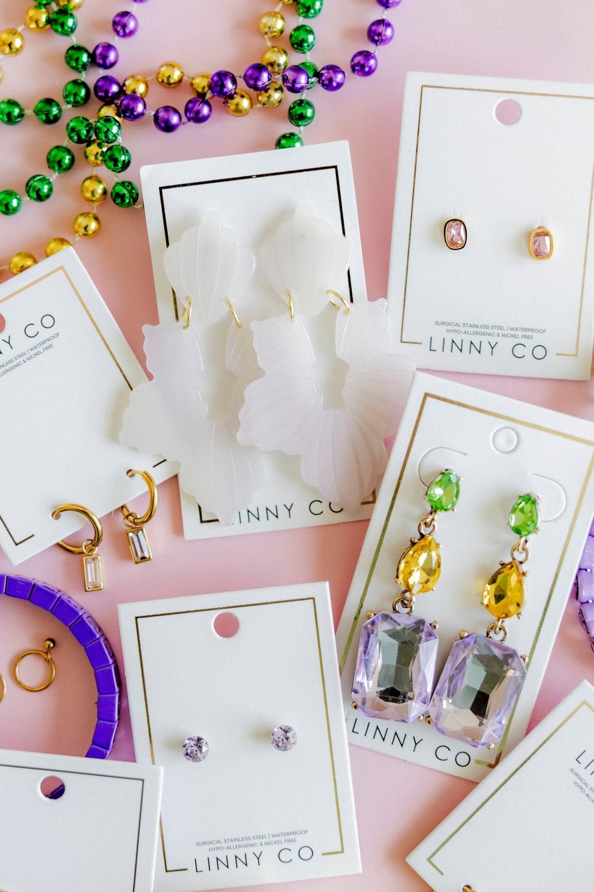 Dangling statement earrings with green tops, yellow drops, and purple crystal centers