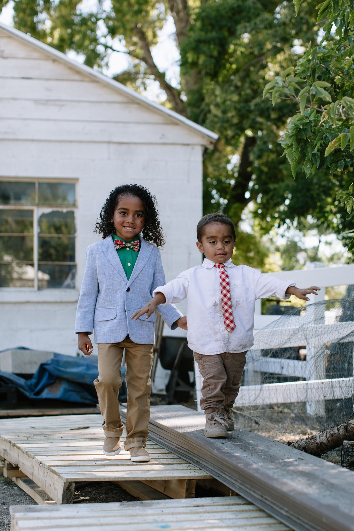 Boys red plaid neck tie with white shirt, standing outdoors